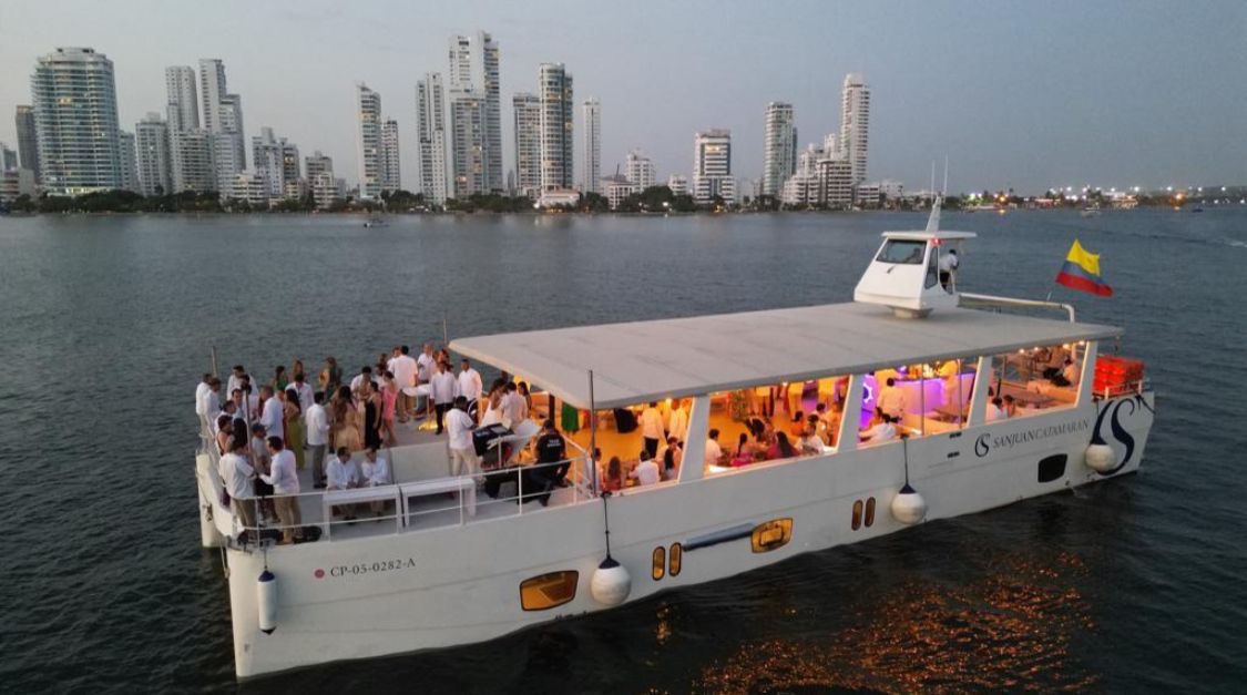 Catamarán San Juan navegando frente al skyline de Cartagena al atardecer